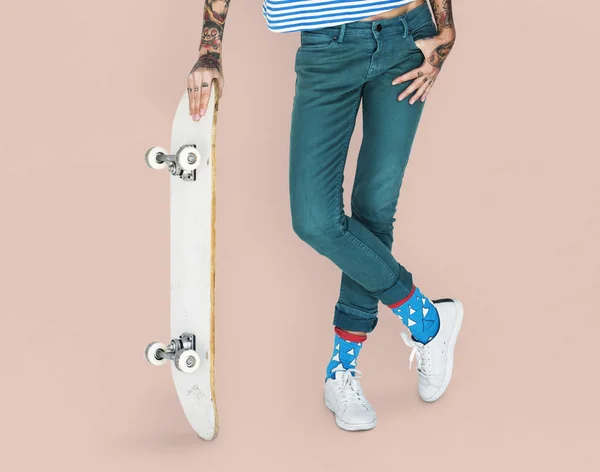 Vrouw bedrijf skateboard — Stockfoto