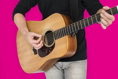 Adam akustik gitar çalıyor.