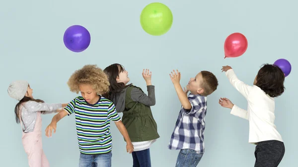 Группа детей, играющих с цветными воздушными шарами — стоковое фото