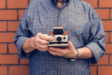 adam retro anlık fotoğraf makinesi ile