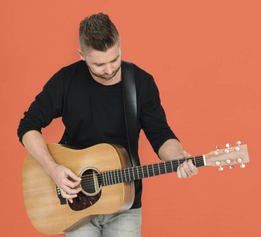 Adam akustik gitar çalıyor.
