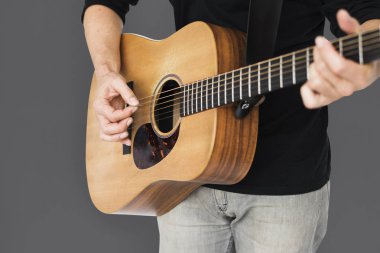 Adam akustik gitar çalıyor.
