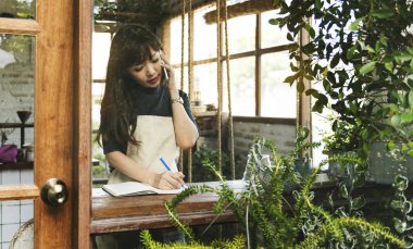 kadın çiçekçi telefonu kullanarak