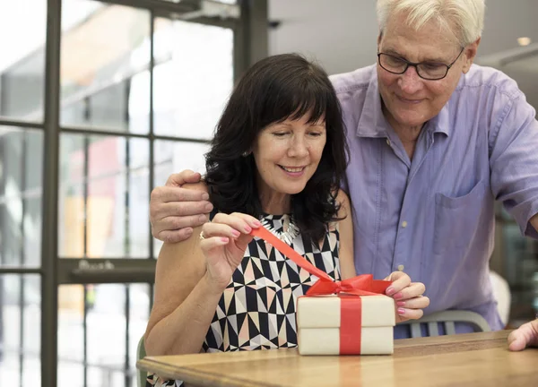 Rijpe vrouw uitpakken cadeau — Stockfoto