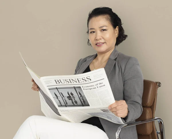 Азиатская деловая женщина с газетой в руках — стоковое фото