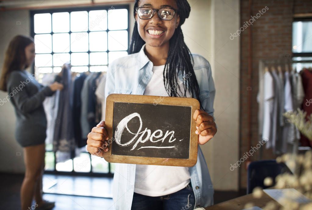 woman holding opening shop board