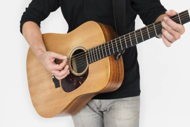 Adam akustik gitar çalıyor.