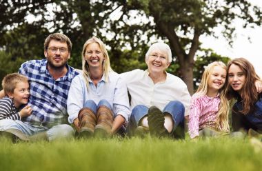 neşeli aile çimenlerin üzerinde oturan