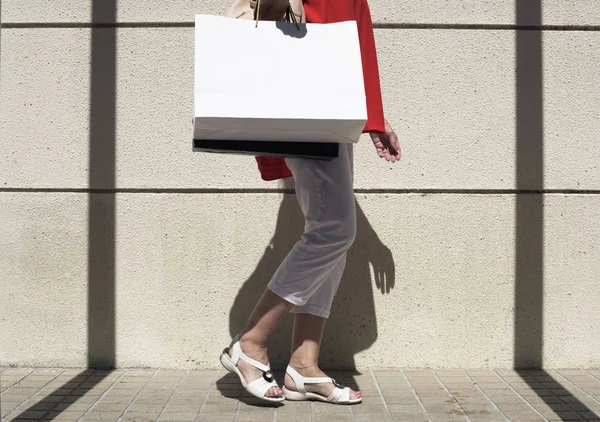 Femme marche avec des sacs à provisions — Photo