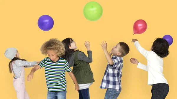 Groupe d'enfants jouant avec des ballons colorés — Photo