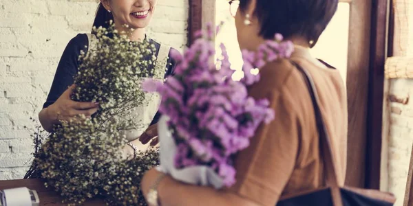 Female florist selling bouquet to customer — Stock Photo, Image