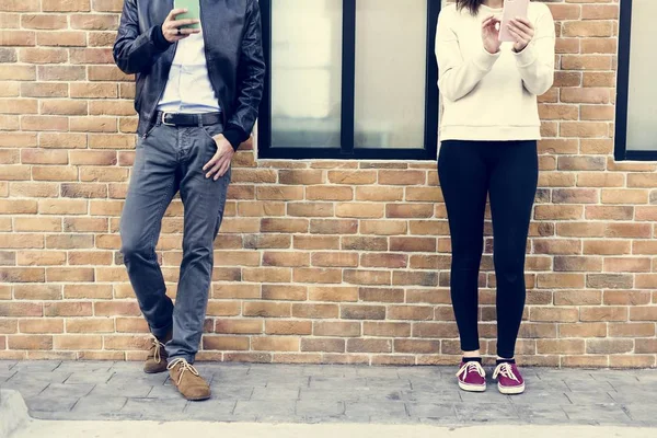 Homem e mulher de pé com smartphones — Fotografia de Stock