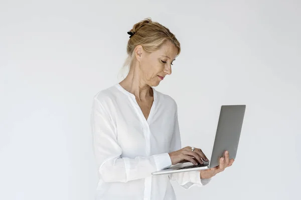 Женщина улыбается и работает на ноутбуке — стоковое фото