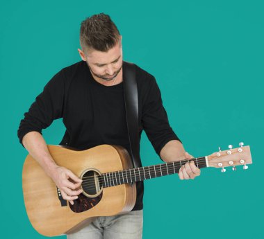 Adam akustik gitar çalıyor.