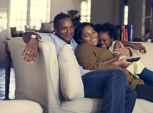 Famiglia guardando la tv sul divano — Foto Stock