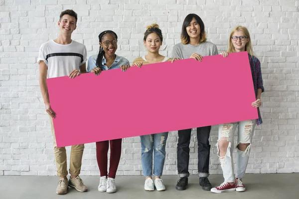 Amigos sosteniendo la pancarta juntos — Foto de Stock