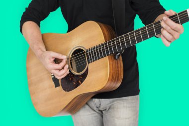 Adam akustik gitar çalıyor.
