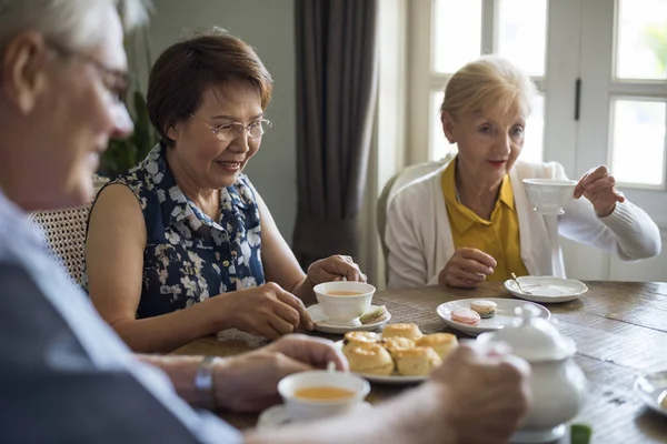 Personas mayores en la mesa celebrando — Foto de Stock