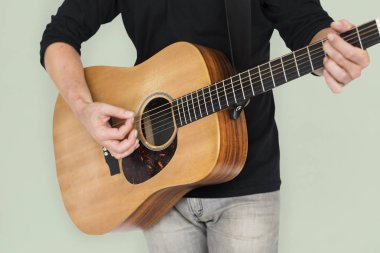 Adam akustik gitar çalıyor.