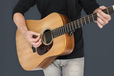 Adam akustik gitar çalıyor.