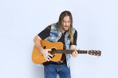 Adam akustik gitar çalıyor. 