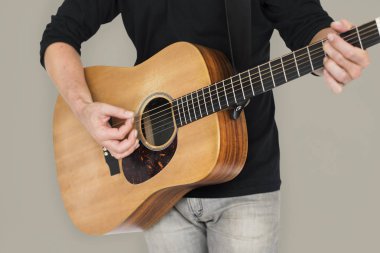 Adam akustik gitar çalıyor.
