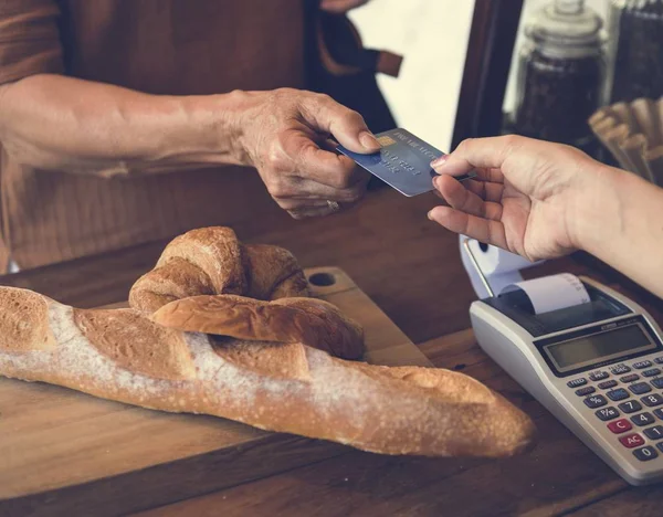 Client giving credit card to baker