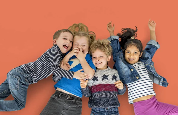 Multi ethnic children laying on floor — Stock Photo, Image