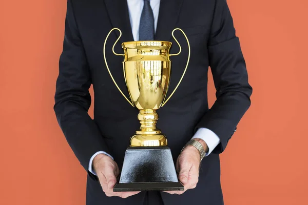 Homem de negócios segurando troféu prêmio — Fotografia de Stock