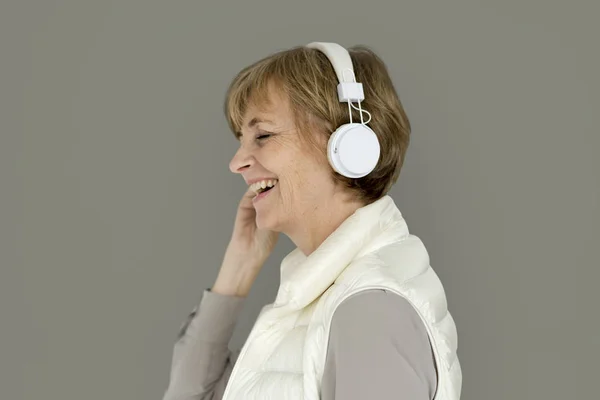Uśmiechający się starsza kobieta słuchania muzyki — Zdjęcie stockowe