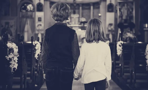 Crianças de mãos dadas em pé na igreja — Fotografia de Stock