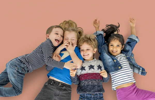 Multi ethnic children laying on floor — Stock Photo, Image