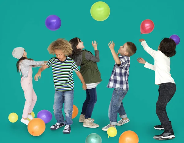 Niños jugando con globos de colores —  Fotos de Stock