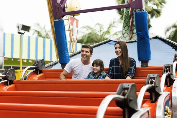Família se divertindo no parque de diversões — Fotografia de Stock
