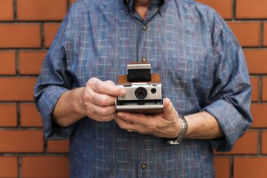 Adam holding anlık fotoğraf makinesi