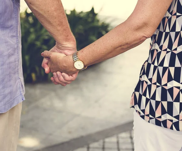 Mature people holding hands — Stock Photo, Image