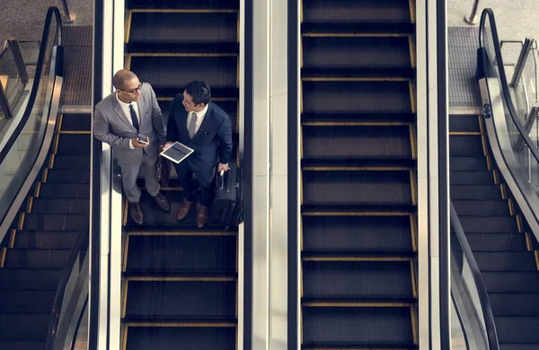 Empresários em pé na escada em movimento — Fotografia de Stock