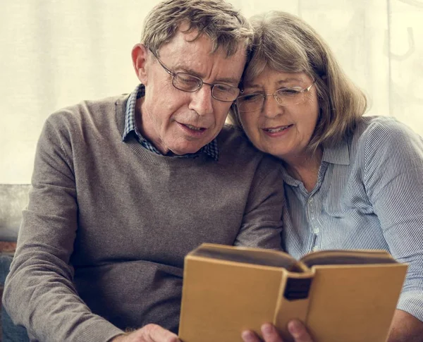Seniorenpaar liest Buch — Stockfoto