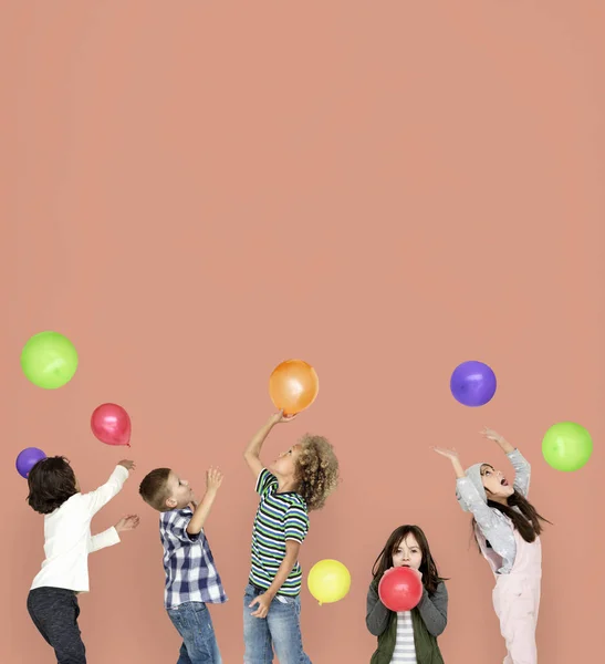 Niños jugando con globos de colores —  Fotos de Stock