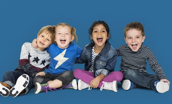 Niños felices sentados en el suelo —  Fotos de Stock