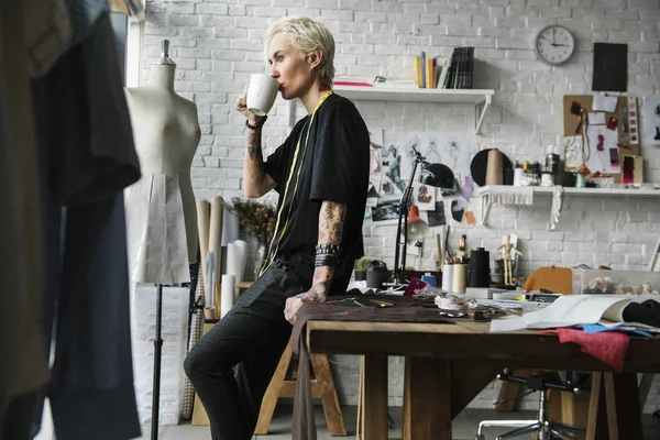 Junge Frau trinkt Kaffee in Werkstatt — Stockfoto