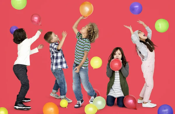 Діти грають з різнокольоровими повітряними кулями — стокове фото