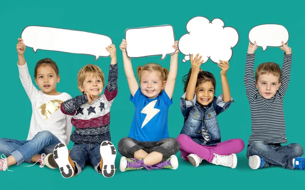 Niños sosteniendo burbujas del habla —  Fotos de Stock