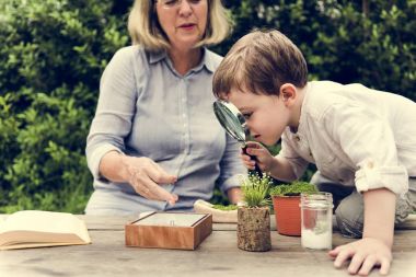 Grandmother with grandson in garden clipart