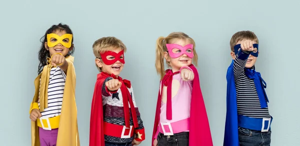 Barn i superhjälte dräkter pekande fingrar — Stockfoto