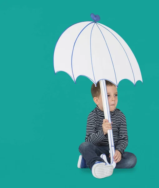 Niño sosteniendo paraguas de papel — Foto de Stock