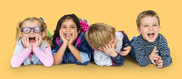 Niños multiétnicos tendidos en el suelo — Foto de Stock