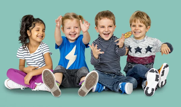 Niños felices sentados en el suelo —  Fotos de Stock