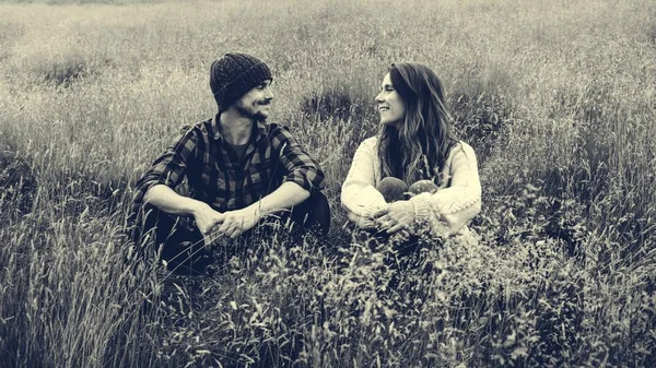Para siedzi w wysokiej trawie pola — Zdjęcie stockowe