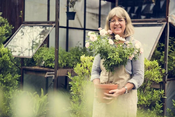 Mulher sênior com flores — Fotografia de Stock